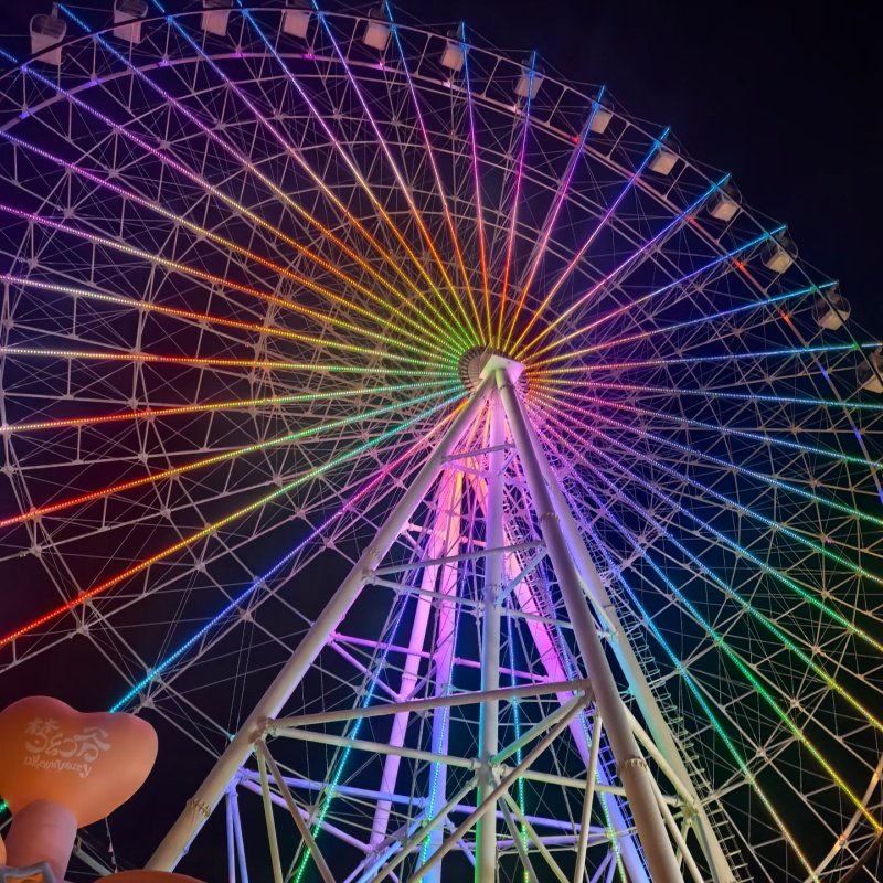 Ferris wheel illuminated at night with colorful LED lights for stunning visual effect